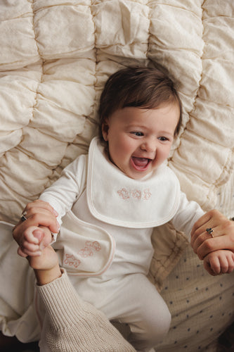 Mema Knits Embroidered Stitch Teddy Bib - Winter White/Pink Stitching